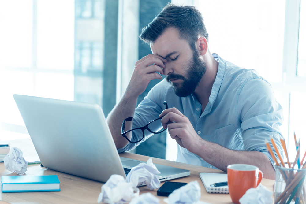 Frustrated and tired engineer working at his desk