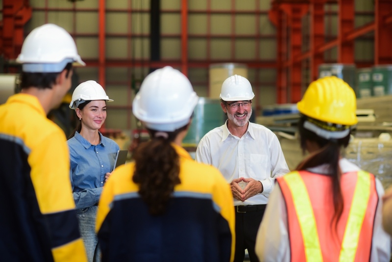 Senior engineer smiling and laughing with crew during team meeting, team culture, company culture