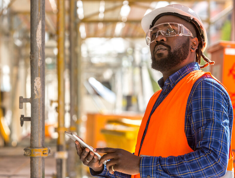 African american engineer in sfaety gear and goggles, inspecting project equipemnt