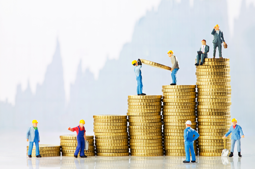 stacks of coins with mini construction workers standing next to and on top of them