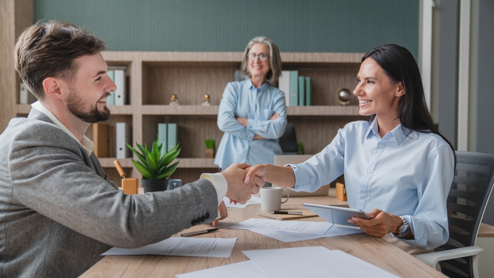 Interviewer shaking hands with engineering job candidate
