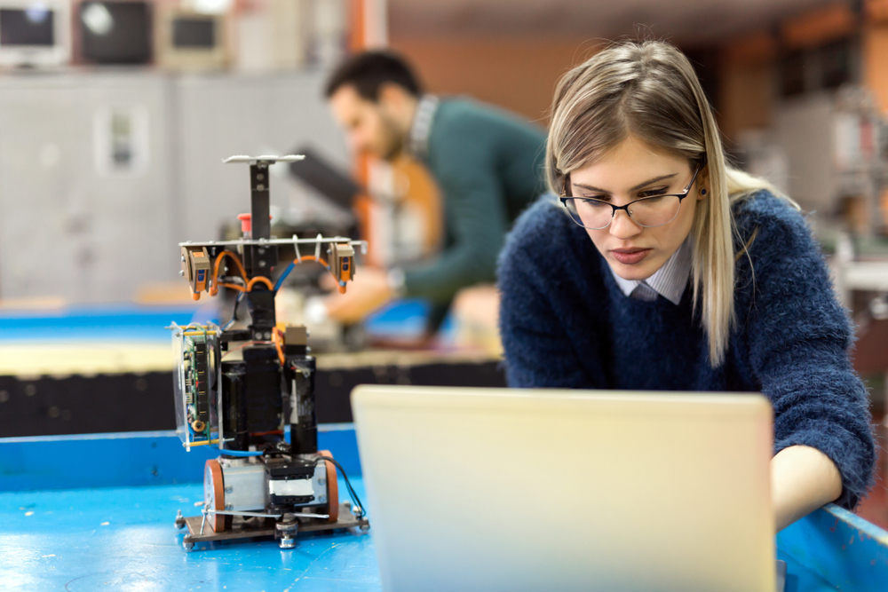 Young engineer working on a robotics project, studying mechanical engineering
