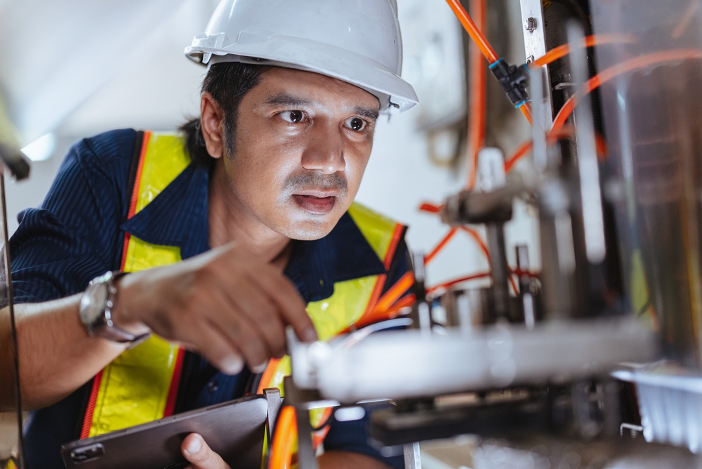 Factory technician working service machine. Asian Engineer male work inside high technology machine