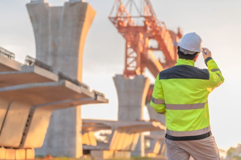 A male engineer works at a motorway bridge construction site, Civil engineer inspecting work on crossing construction,Supervisor working at high-speed railway construction site
